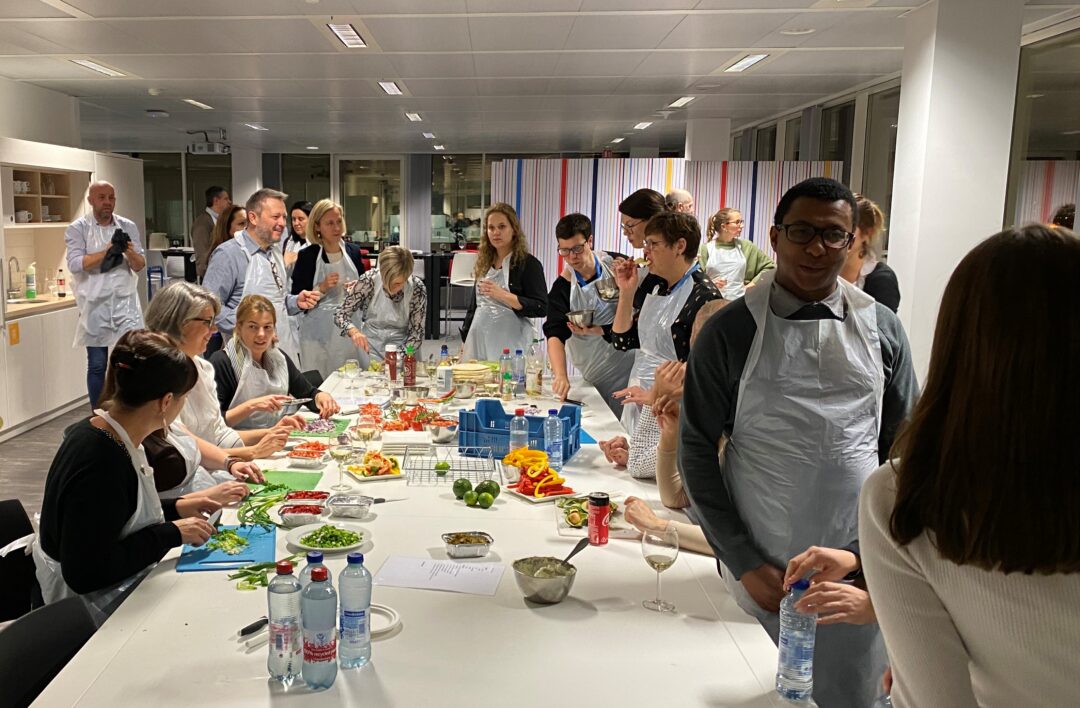 Kookworkshop in een professionele keuken met deelnemers en chef
