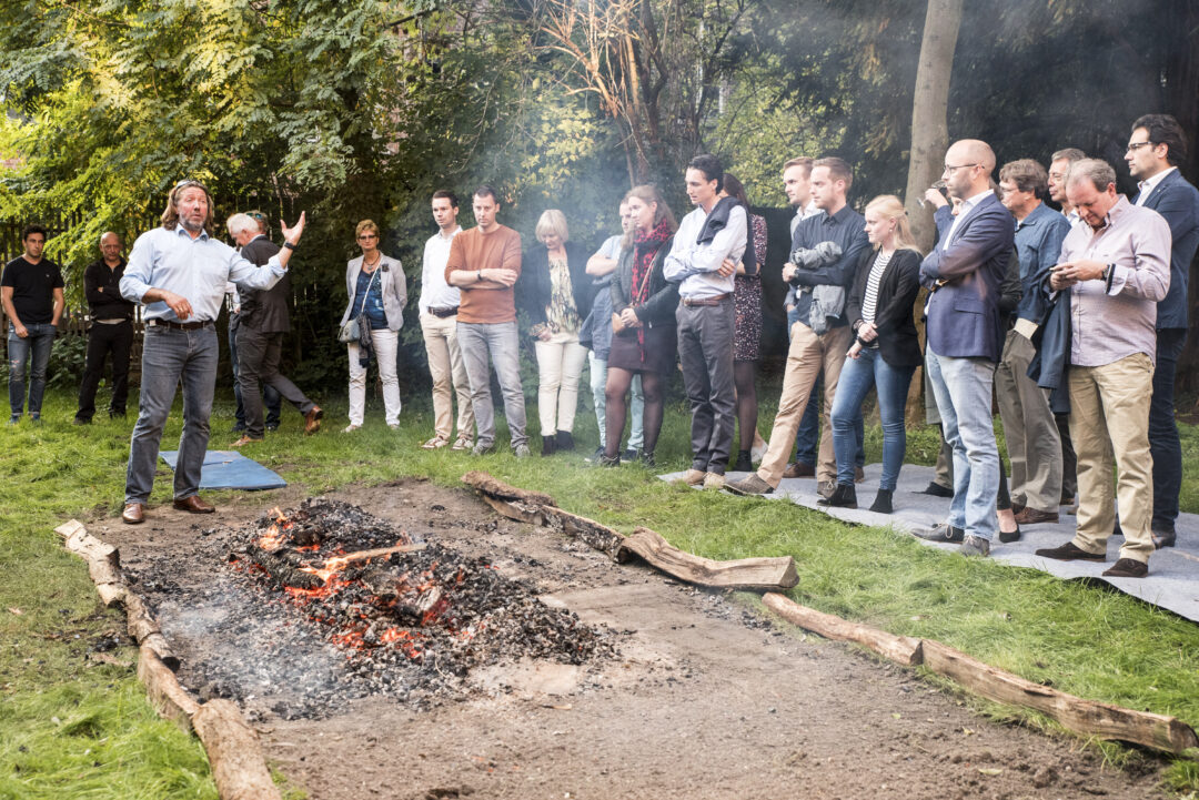 Vuurlopen ervaring met groep rond gloeiende kolen