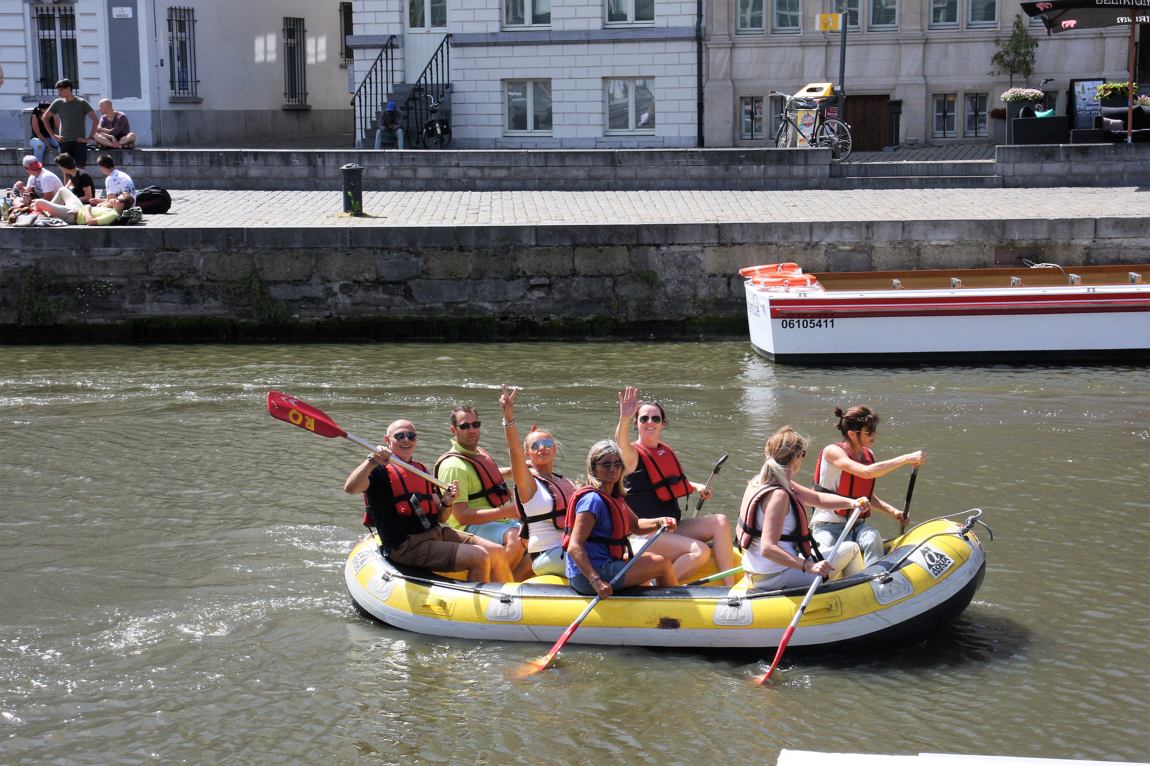 Bedrijfsteam vaart in een raft over de Leie in Gent tijdens de teambuilding